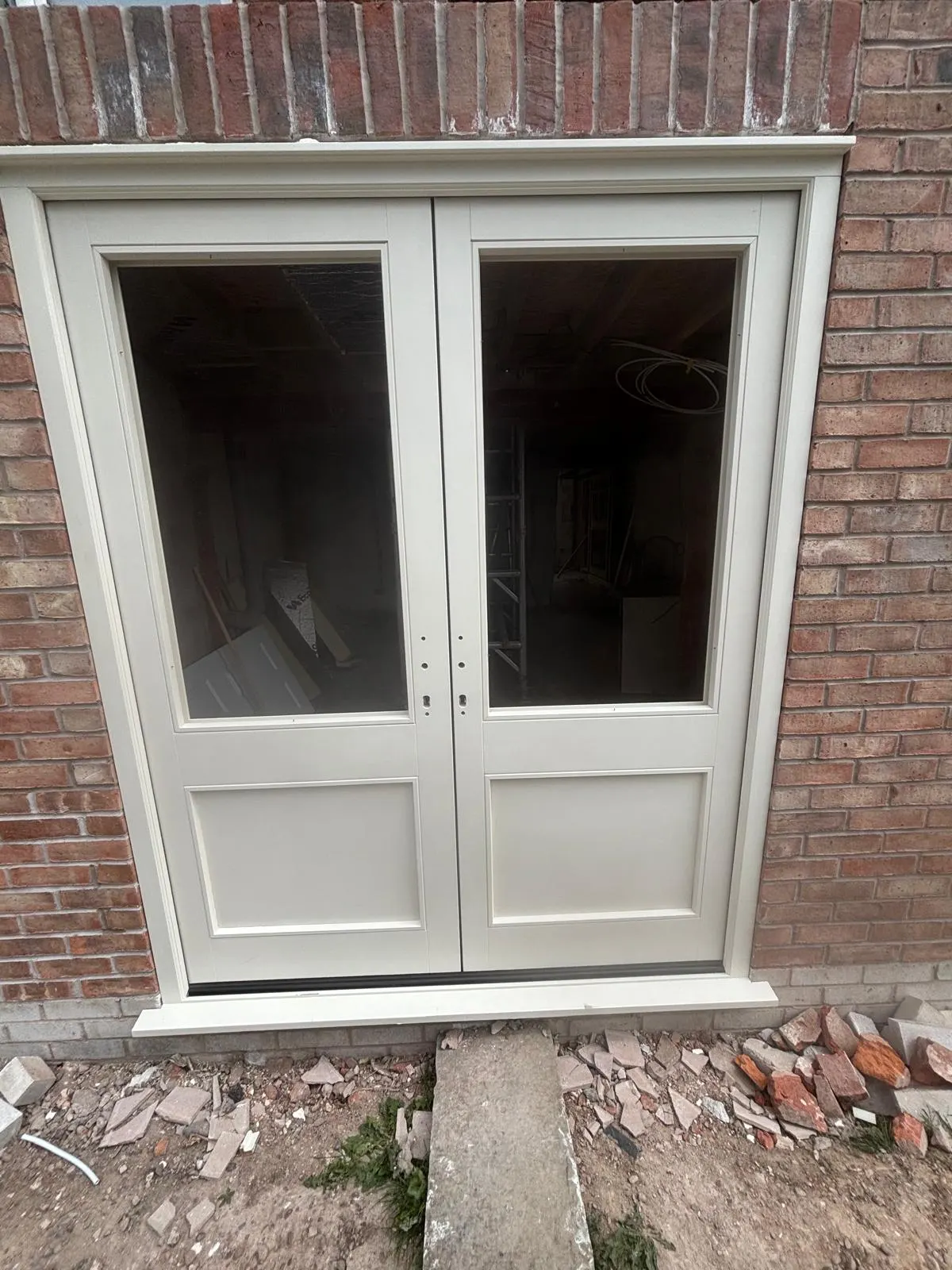 White glazed double doors set within a brick opening